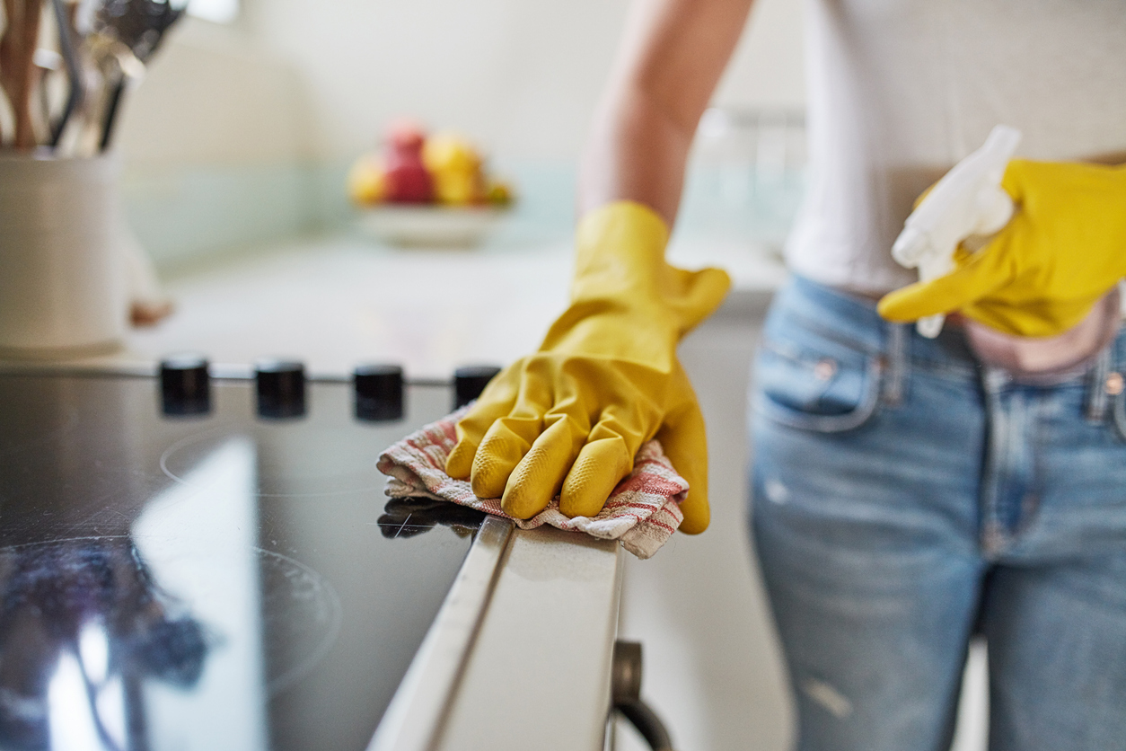 Shot of an unrecognizable woman begining her spring cleaning by wiping down her appliances.