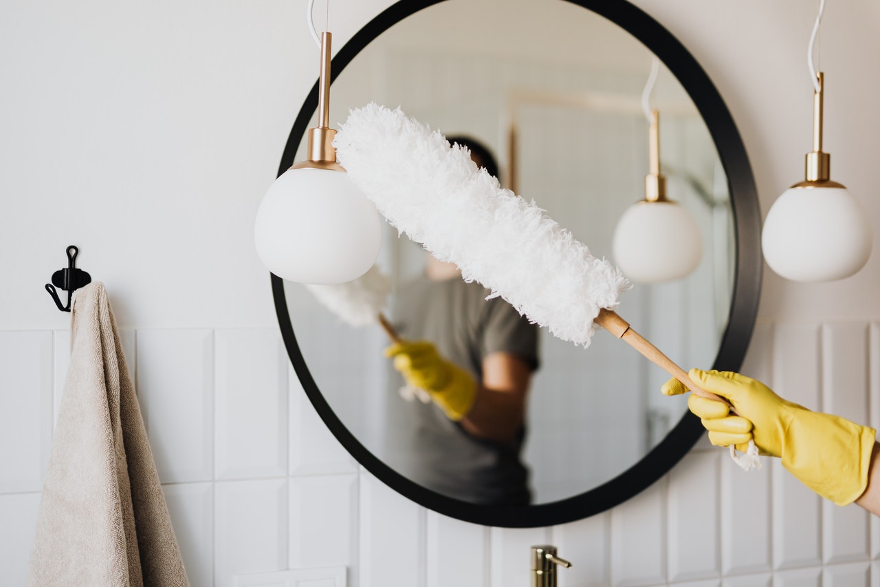 A woman cleaning a mirror in her home
