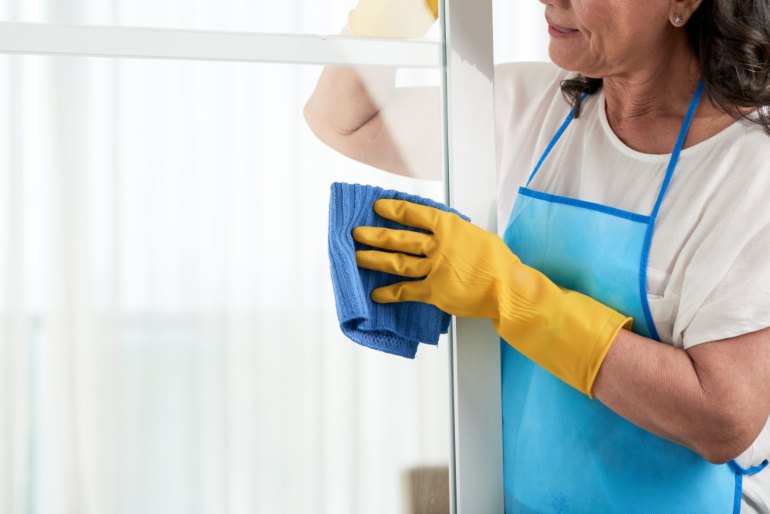 Woman cleaning a window with a cloth