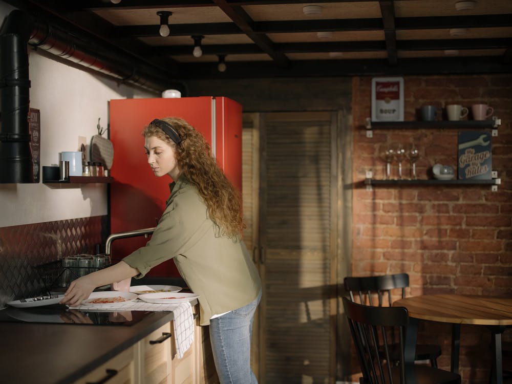 A woman clearing the counters before her house cleaner arrives