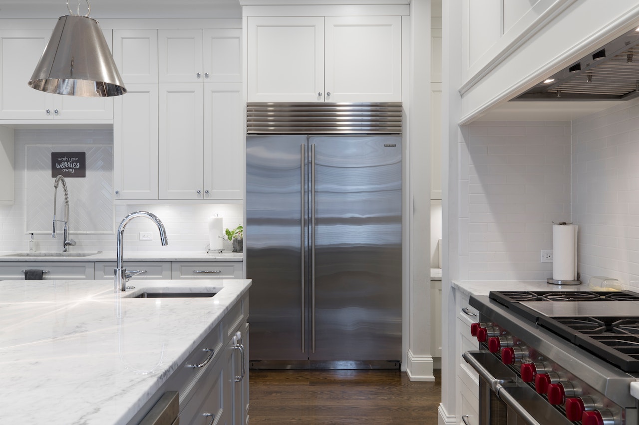 A stainless steel fridge in a white kitchen.