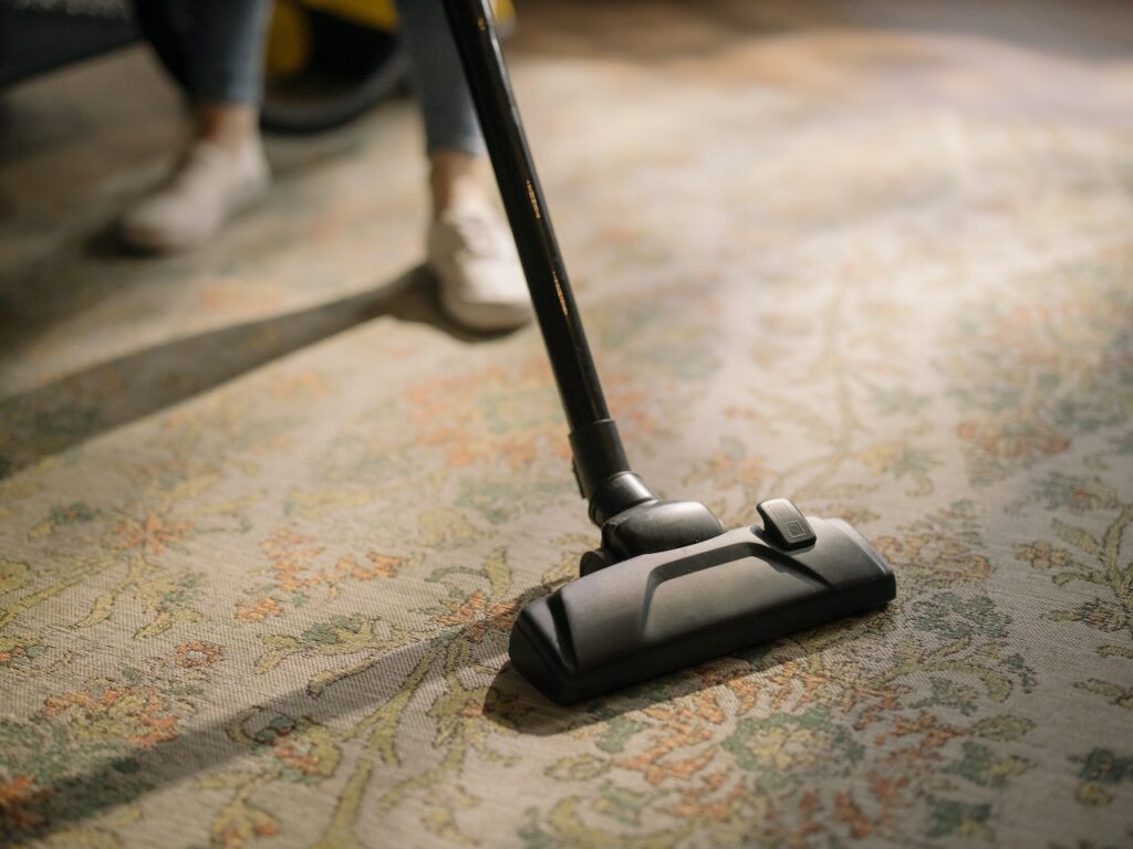 A person staying active by vacuuming.